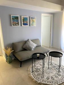 een woonkamer met een bank en 2 tafels bij Appart vue mer coeur ville - Casa Riviera Bellevue in Sainte-Maxime