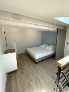 een kleine kamer met een bed en een bureau bij Appart vue mer coeur ville - Casa Riviera Bellevue in Sainte-Maxime