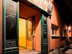un edificio con una puerta y una señal en él en Pension Rüssel-Pub, en Sangerhausen