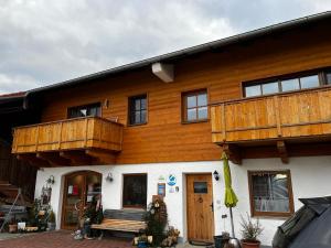 a large wooden house with a porch and balcony at Thallerhof in Griesstätt