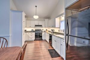 a kitchen with white cabinets and a black refrigerator at Walkable Sodus Point Retreat Less Than 1 Mi to Lake in Sodus