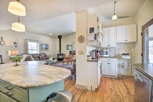 a kitchen and living room with a large counter top at Charming Cody Home, Walk to Downtown! in Cody
