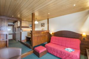 Il comprend un salon avec un canapé rouge et une cuisine. dans l'établissement Résidence Pierre & Vacances Le Mont d'Arbois, à Megève