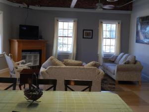 a living room with two couches and a table at Corner loft with river views in Salisbury