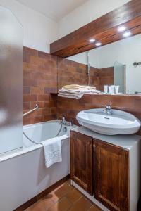 a bathroom with a sink and a bath tub at Résidence Pierre & Vacances Le Mont d'Arbois in Megève