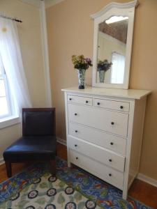 a dresser with a mirror and a chair in a room at 2 bed, 1 bath riverfront loft in Salisbury