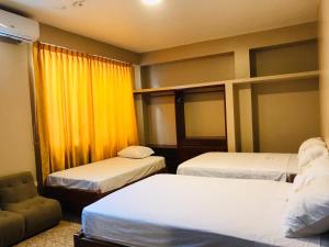 pokój hotelowy z dwoma łóżkami i kanapą w obiekcie HOSTAL VS w mieście Iquitos