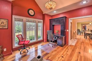 una oficina con paredes rojas, escritorio y sillas en Spacious Statesboro House with Private Pool!, en Statesboro