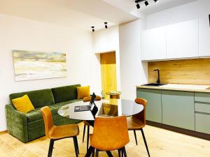 a living room with a green couch and a table and chairs at Agrigento Boutique Apartments in Agrigento