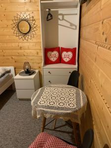 Zimmer mit einem Tisch und roten Kissen auf einem Schrank in der Unterkunft Agroturystyka Wudarsówka in Sokolec