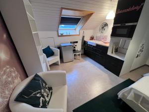 een kleine kamer met een keuken en een woonkamer bij Gemütlich wohnen in Messenähe, Feenzian in Friedrichshafen