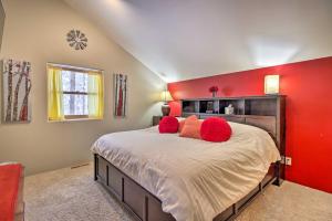 - une chambre dotée d'un mur rouge et d'un lit avec des oreillers rouges dans l'établissement Spacious and Secluded Home by Pokegama Lake!, à Grand Rapids