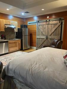 Dormitorio con cama grande y puerta corredera de granero en Cajun-Get Away, en Breaux Bridge
