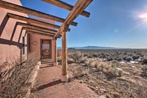 El Prado的住宿－Southwest Home with 360-Degree Mtn View, Ski Nearby!，天空中阳光灿烂的沙漠中的房子