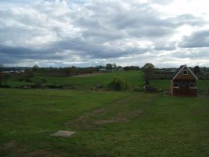 a barn in a field with a green field at 'Little Acre' perfect for business or pleasure in Portadown