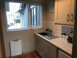 a kitchen with a sink and a window at 'Little Acre' perfect for business or pleasure in Portadown