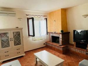 sala de estar con chimenea y TV en Holiday home in Francavilla di Sicilia, en Francavilla di Sicilia