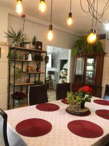 un comedor con una mesa con platos rojos. en Casa na praia do Campeche, en Florianópolis