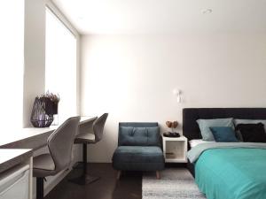 a bedroom with a bed and a desk and a chair at Modern Courtyard Condo in Liepāja