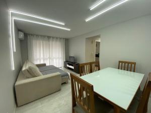 uma sala de estar com um sofá e uma mesa de jantar em Lindo apto reformado no coração de BC no Balneário Camboriú