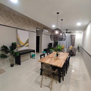 a dining room with a table and a living room at The Apple Premier Condo in melaka in Melaka