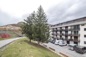 un árbol en un estacionamiento al lado de un edificio en L'Espiaube, en Saint-Lary-Soulan