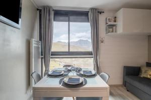 una mesa en una habitación con una ventana grande en L'Espiaube, en Saint-Lary-Soulan