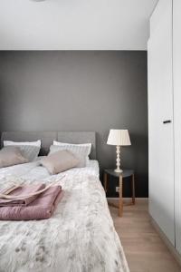 1 dormitorio con 1 cama y 1 mesa con lámpara en Loimu, en Rovaniemi