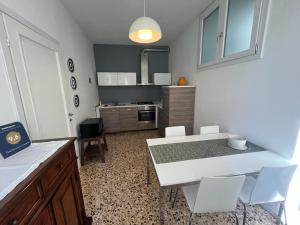 eine Küche mit einem weißen Tisch und weißen Stühlen in der Unterkunft Casa Vacanze Le Violette in Brunate