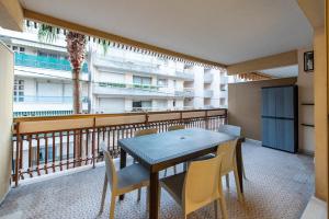 balkon ze stołem i krzesłami oraz balkon z budynkiem w obiekcie VILLA CLIPPER w mieście Juan-les-Pins