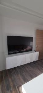T2 tout confort climatisé de Lilou في آكس أون بروفانس: غرفة معيشة مع تلفزيون كبير على جدار أبيض