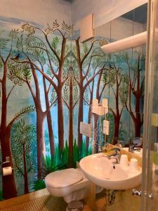 a bathroom with a mural of trees on the wall at Pension Spreewelten in Lübbenau
