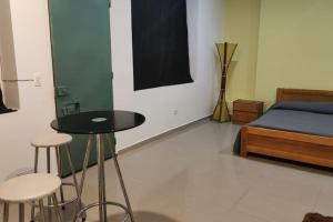 1 dormitorio con cama, mesa y taburetes en Corazón de Bogotá - Vivienda Turística, en Bogotá