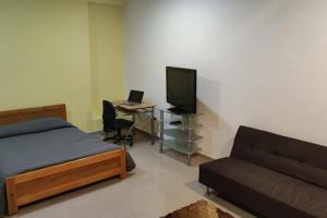 1 dormitorio con 1 cama y escritorio con TV en Corazón de Bogotá - Vivienda Turística en Bogotá
