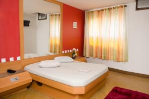 ein Schlafzimmer mit einem Bett und einer roten Wand in der Unterkunft Jumbo Hotel in Rio de Janeiro