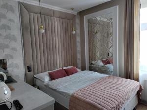 Un dormitorio con una cama grande y un espejo. en BookNow - starówka Zielona Góra, en Zielona Góra