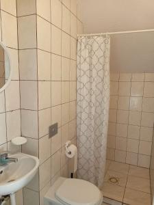 łazienka z toaletą i umywalką w obiekcie Willa Rosa w mieście Kajetany