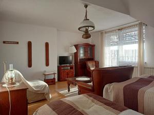 a bedroom with two beds and a chair and a television at Willa Rosa in Kajetany