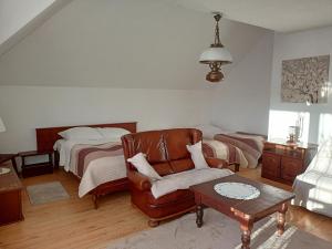uma sala de estar com uma cama e uma cadeira de couro em Willa Rosa em Kajetany