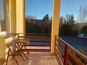 een balkon met 2 stoelen en een tafel. bij Willa Rosa in Kajetany