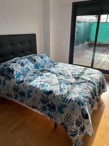 a bed with a blue and white comforter in a bedroom at Loft_Luminoso_Efeso in Madrid