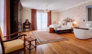 a bedroom with a bed and a tub in a room at The Hawthorn Boutique Hotel in George