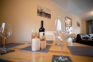 a bottle of wine sitting on a table with two wine glasses at Benview House in Corpach