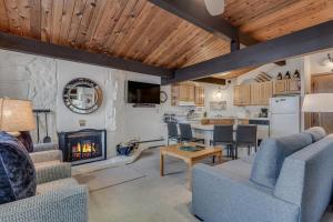 a living room with a fireplace and a kitchen at Laurelwood Condominiums 112 in Snowmass Village