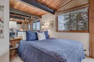 a bedroom with a blue bed and a window at Laurelwood Condominiums 112 in Snowmass Village