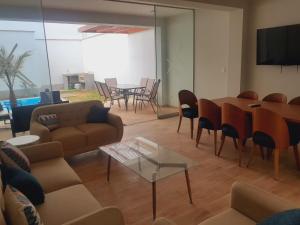 uma sala de estar com um sofá, uma mesa e cadeiras em Hermosa Casa de Playa km 90.5 em Bujama Baja