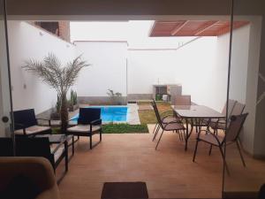 a dining room with a table and chairs and a pool at Hermosa Casa de Playa km 90.5 in Bujama Baja