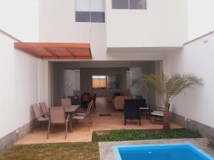 een patio met een tafel en stoelen en een zwembad bij Hermosa Casa de Playa km 90.5 in Bujama Baja