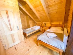 sypialnia z 2 łóżkami w drewnianym domku w obiekcie Góralska Willa Bajka w Międzybrodziu Żywieckim