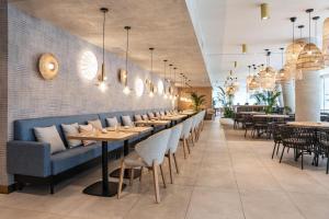 a restaurant with a row of tables and chairs at WAVE private apartment - Fancy Sunset in Międzyzdroje